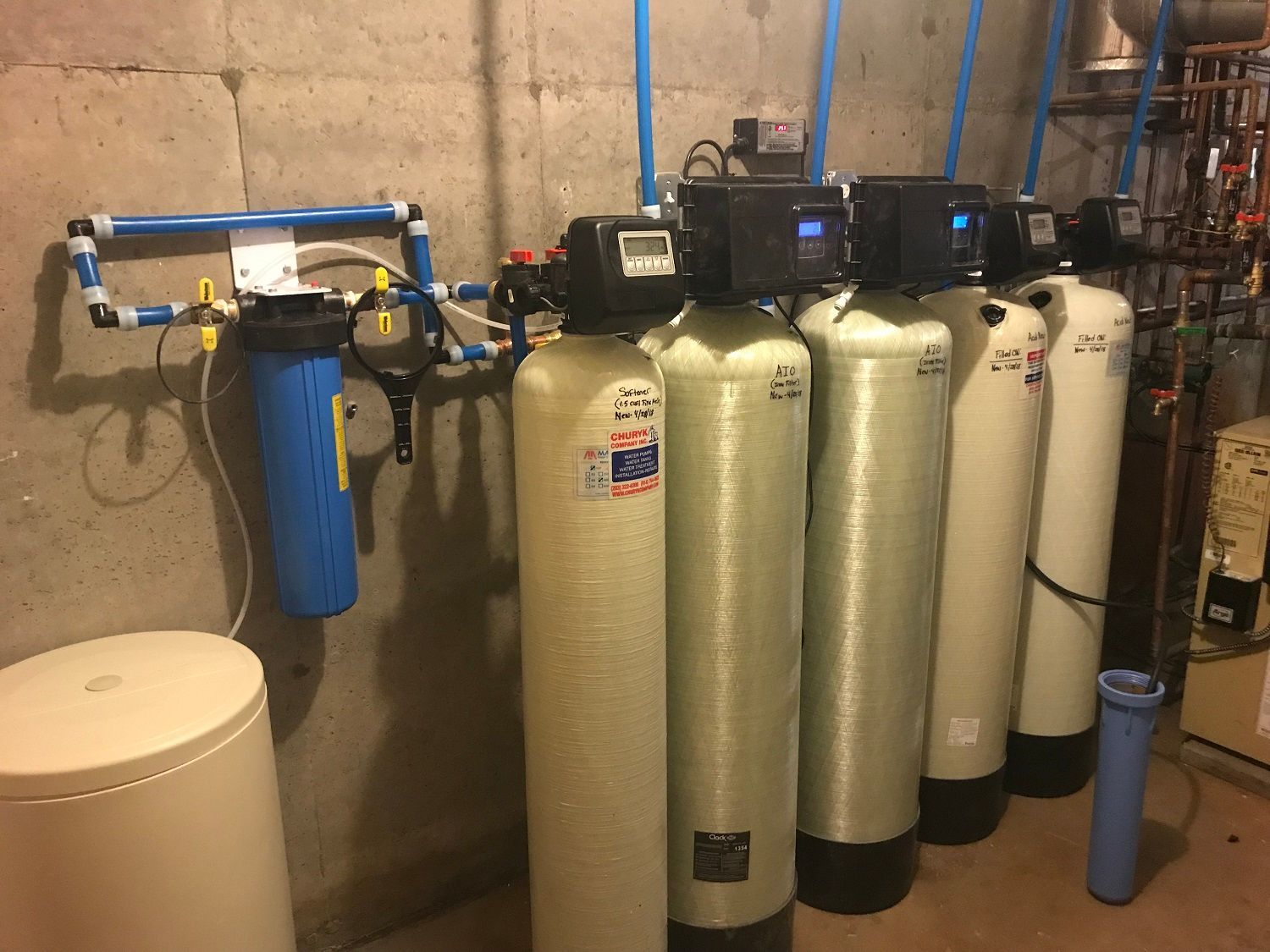 A row of water filters are lined up in a room.