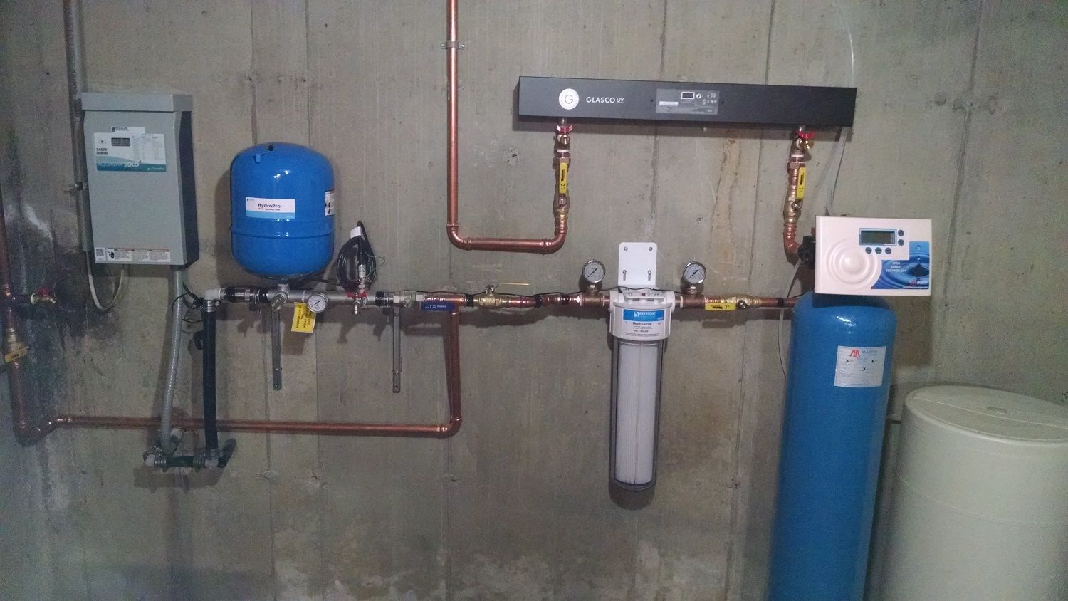 A room with a lot of pipes and a blue tank