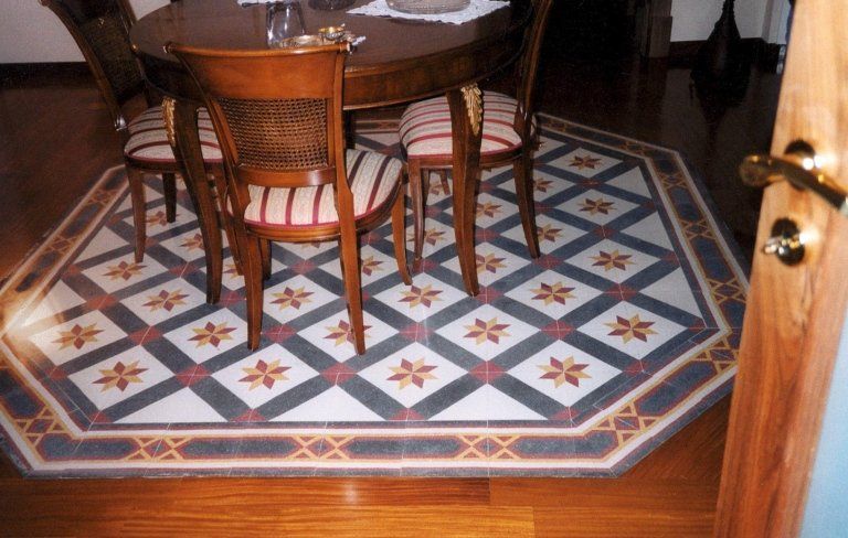 un tavolo in legno e un disegno a mosaico sul pavimento