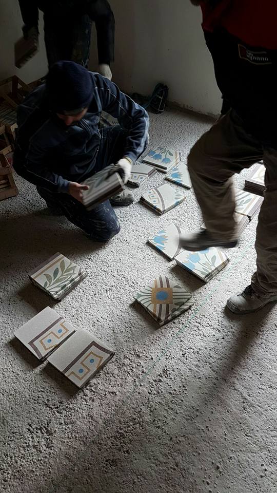 due impiegati mentre installano delle piastrelle