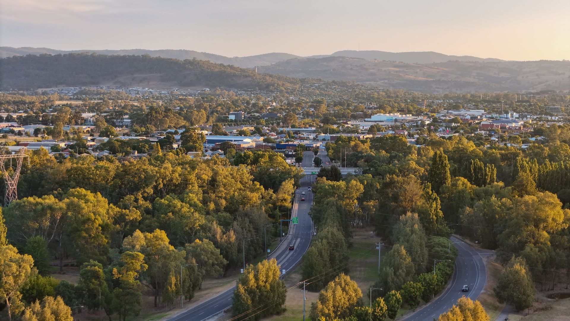 Two-story white house with black garage door, green lawn, blue sky.