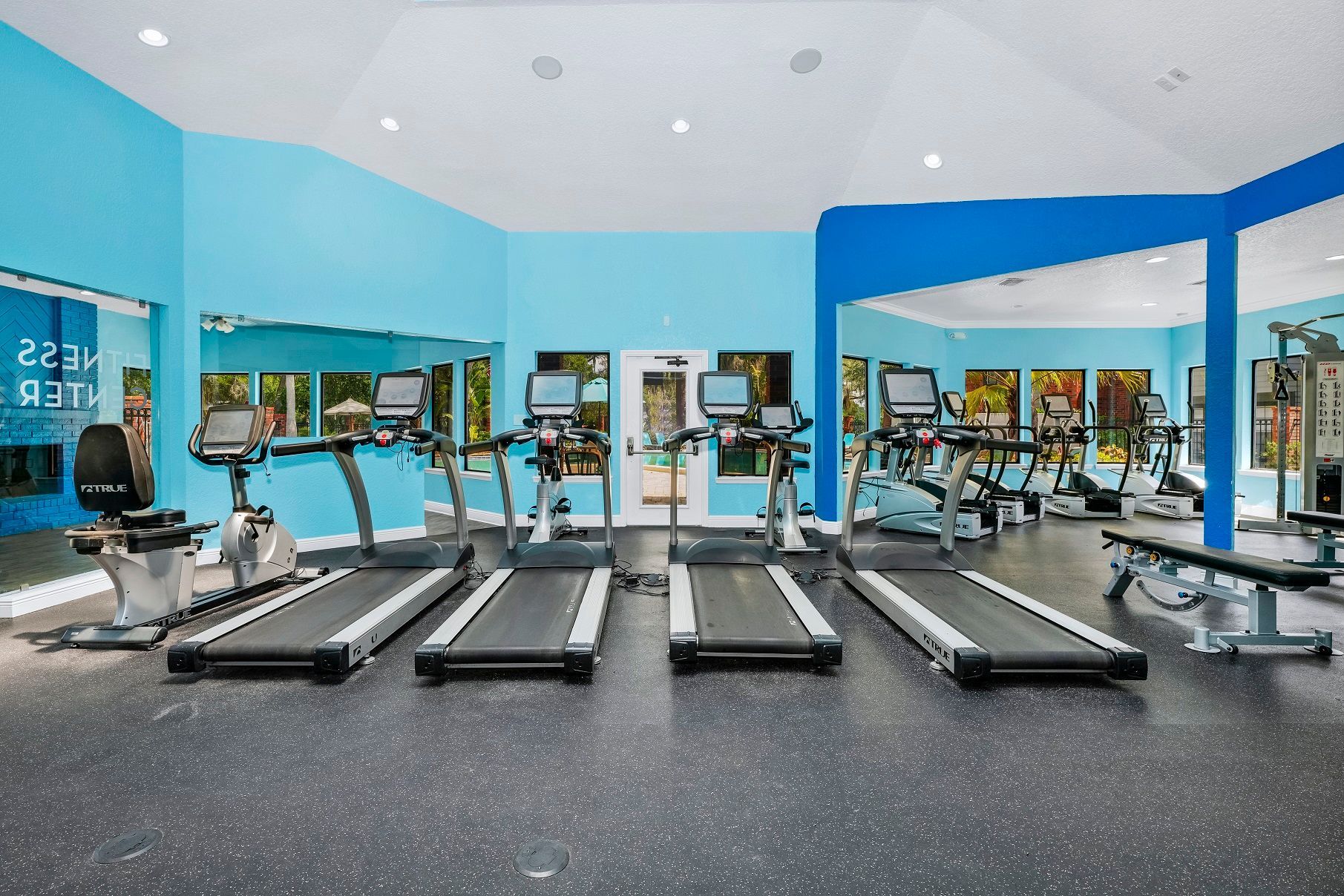 Gym with treadmills, exercise bikes, and weight machines. Light blue walls, dark floor at Timberlake in Altamonte Springs, FL.