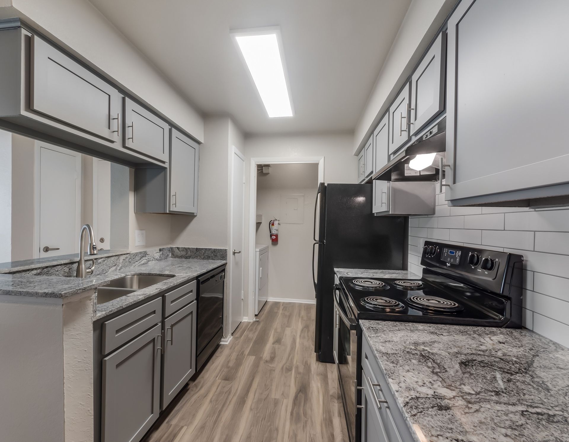 Gray kitchen with countertops, cabinets, appliances, and wood-like flooring at Timberlake in Altamonte Springs, FL.