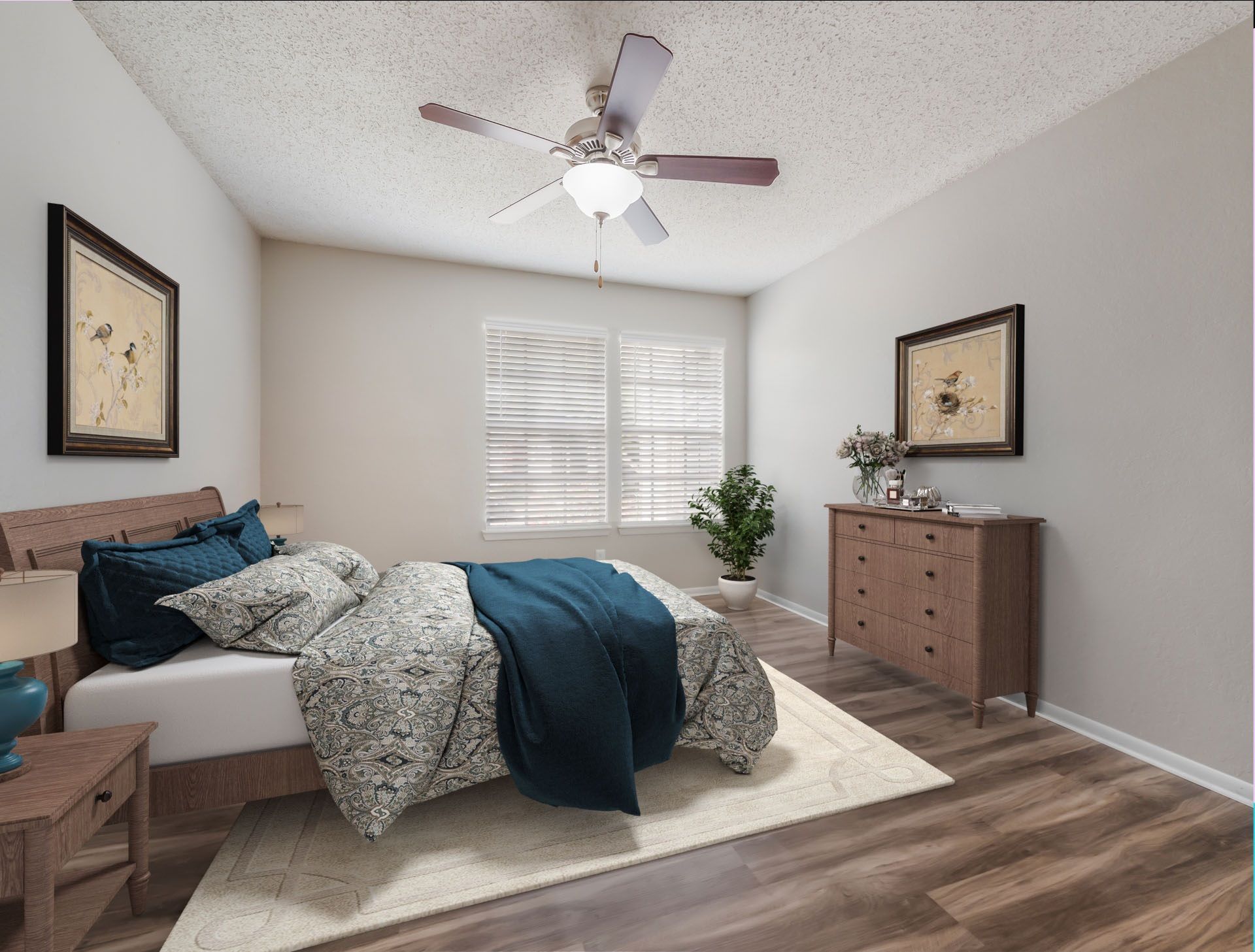 Bedroom with bed, chest of drawers, artwork, and ceiling fan. Wooden floors and neutral walls at Timberlake in Altamonte Springs, FL.