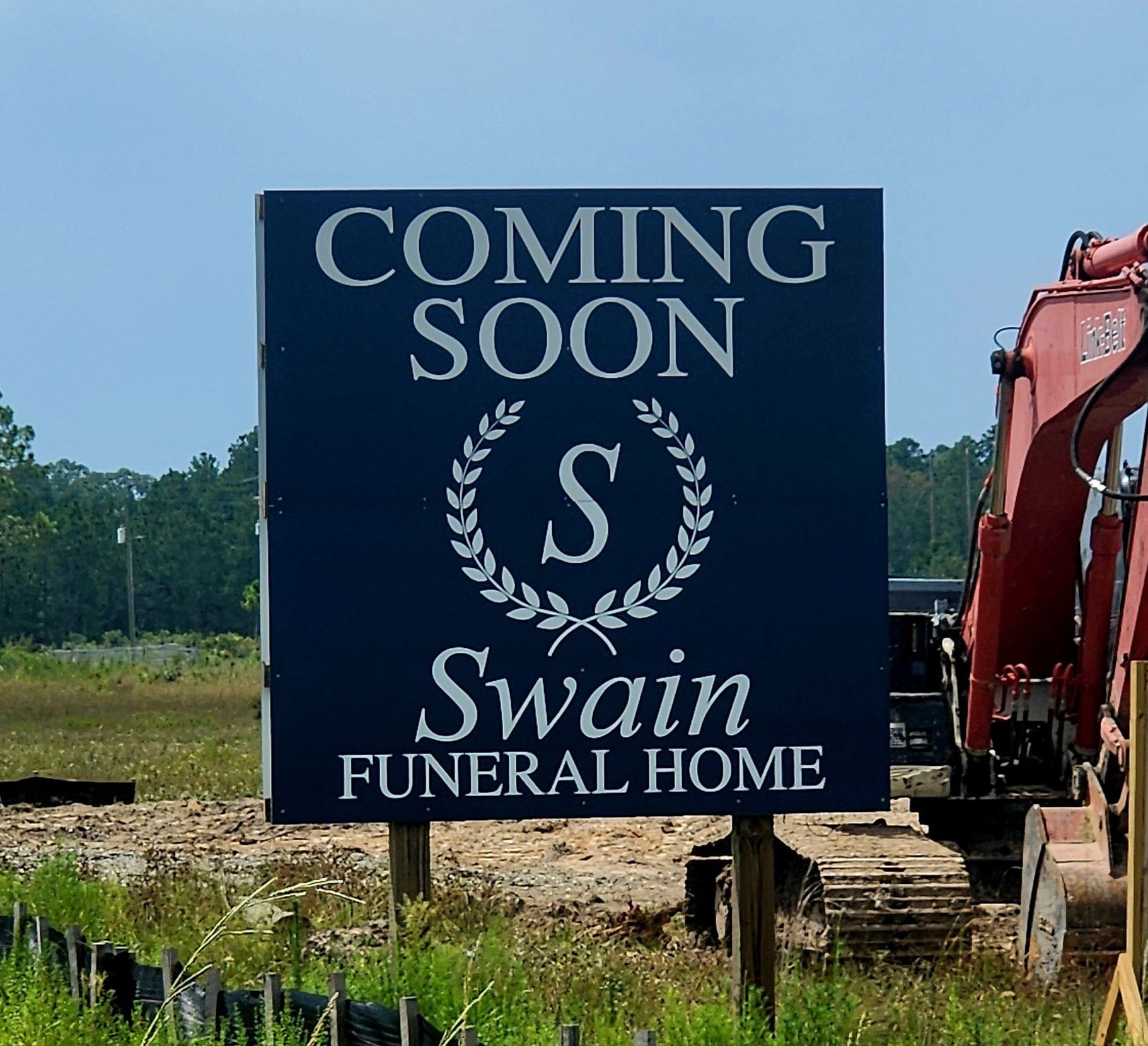 sign on construction site with Swain Funeral Home logo and words that say Coming Soon