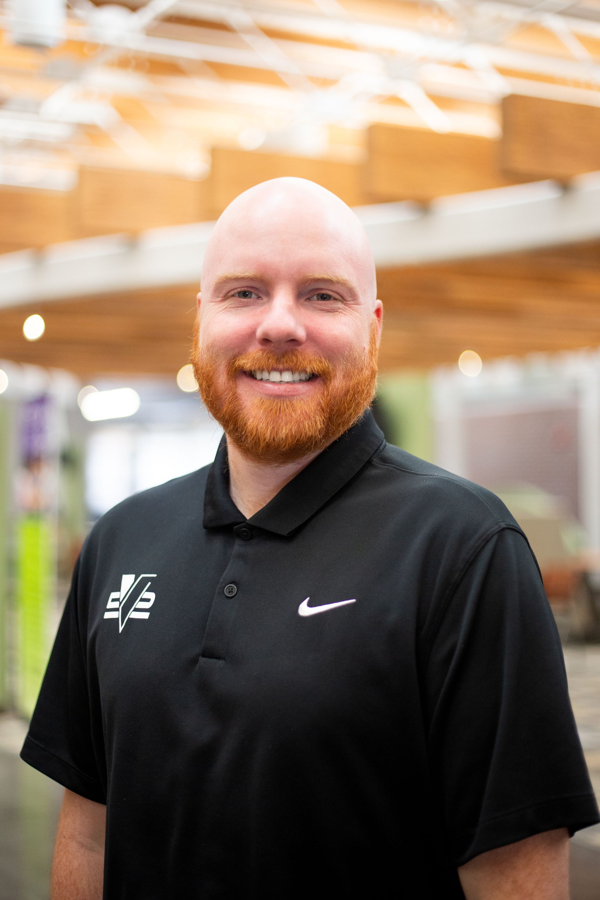 Couple on vacation posing outdoors; woman in swimwear, man in Hawaiian shirt; blue sky, palm tree.