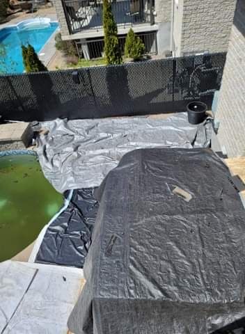 Vue aérienne d'un jardin comprenant une piscine, une terrasse partiellement couverte de bâches et un conteneur de rangement noir.