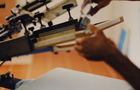 A person is using a machine to print a shirt