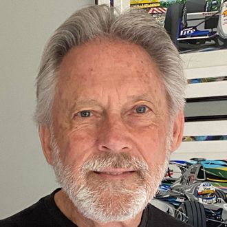 A man with a beard and gray hair is smiling for the camera.