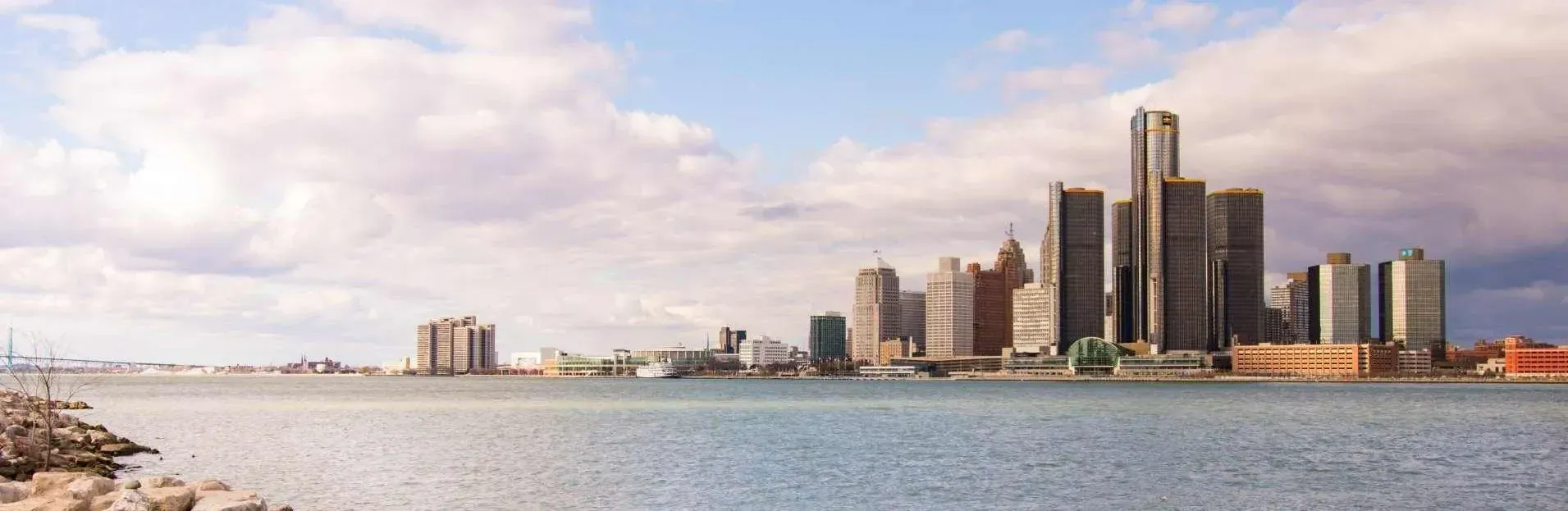 Detroit skyline across the water on a cloudy day.
