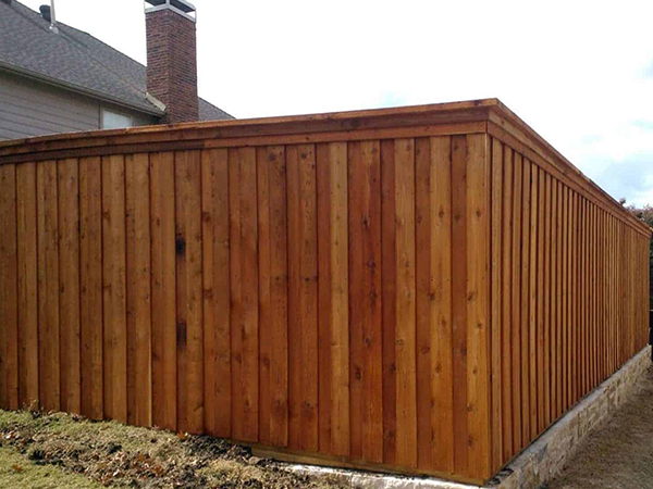 Wooden fence in a yard, stained brown.