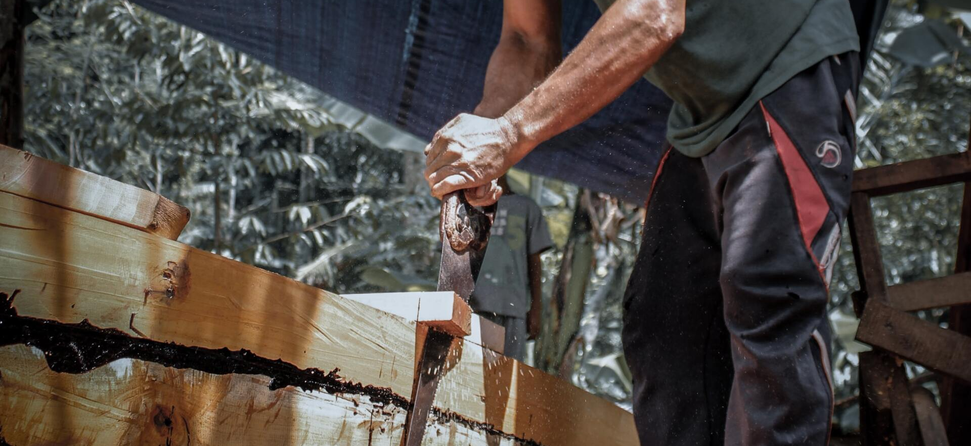 handyman sawing a piece of wood