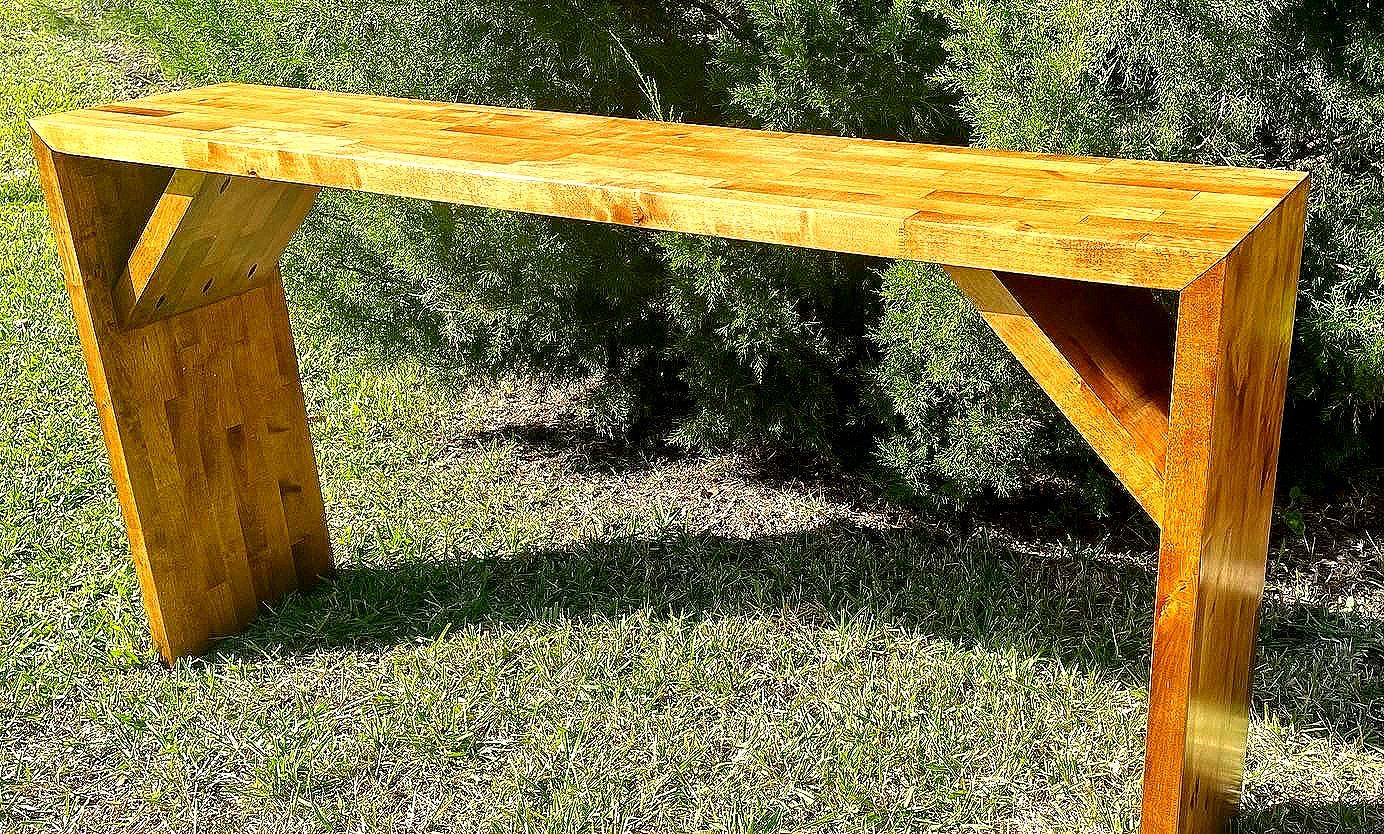 A wooden bench is sitting on top of a lush green field.