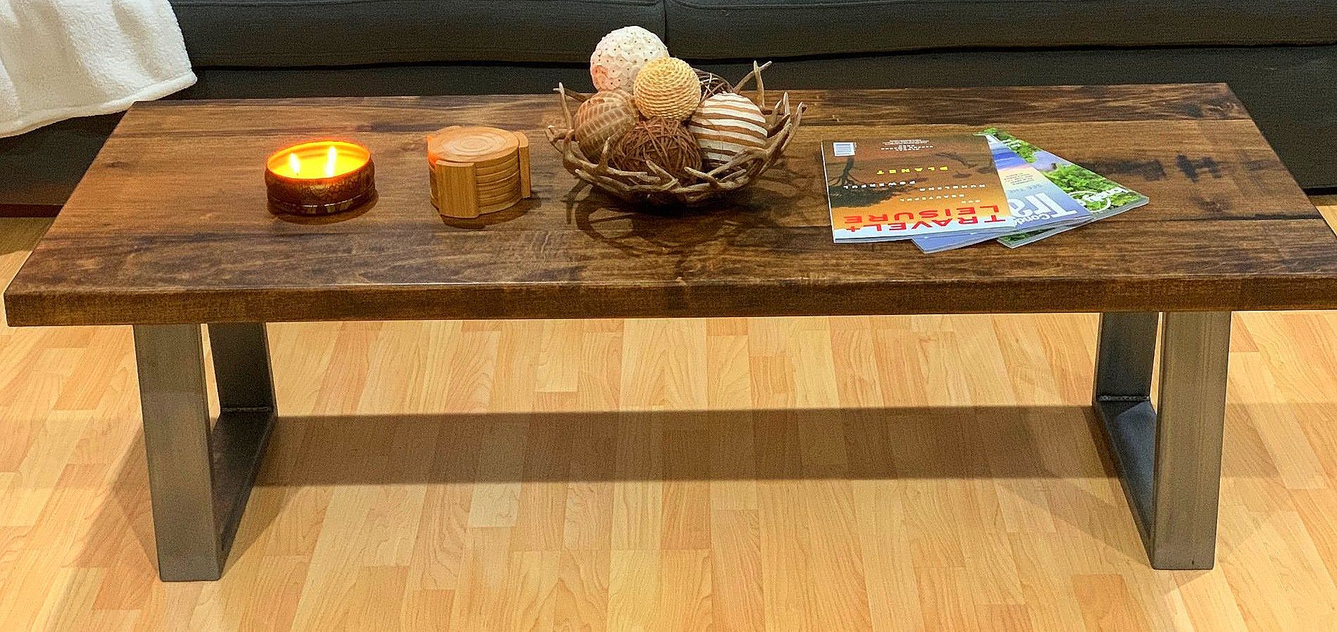 A wooden coffee table with a candle on top of it