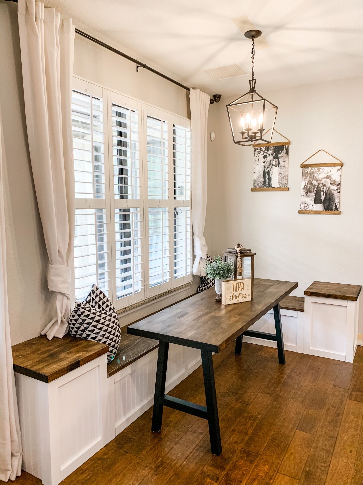 A dining room with a wooden table and bench in front of a window.