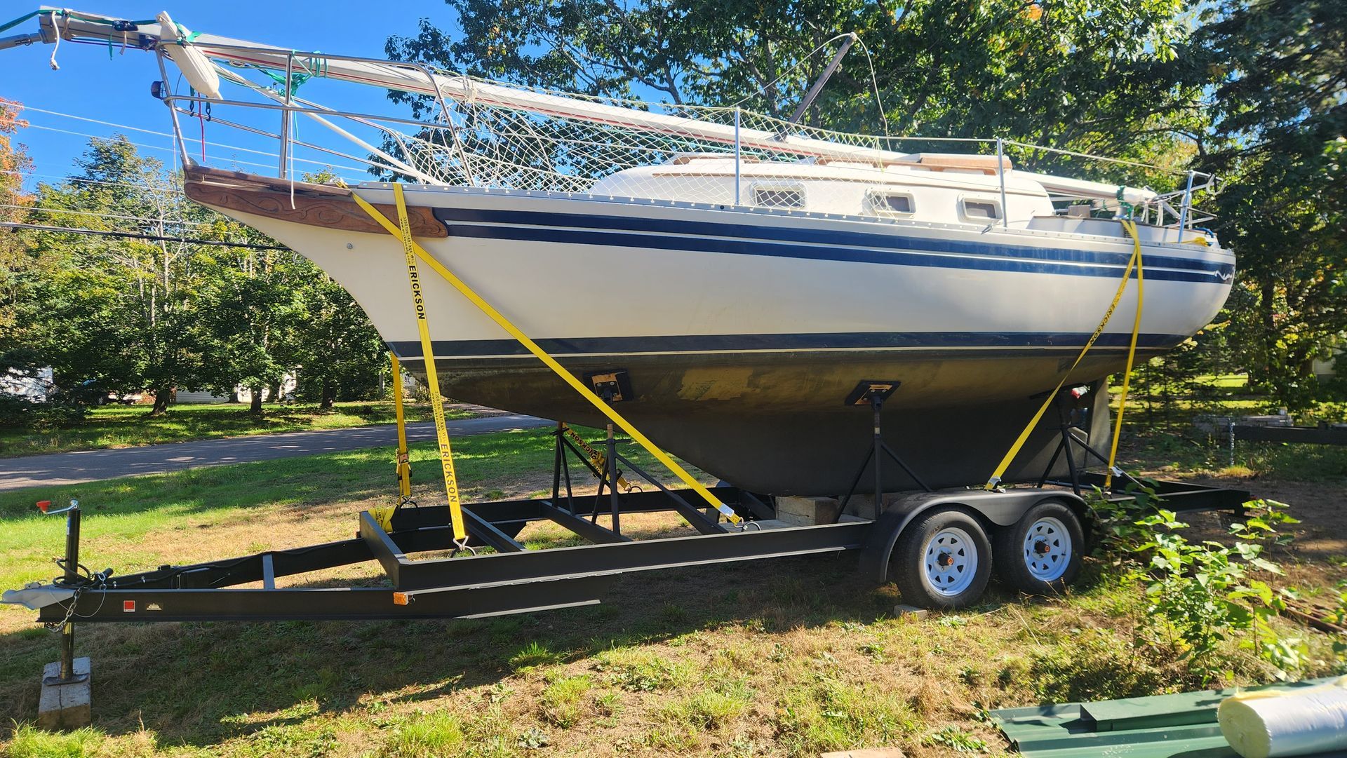 A boat is sitting on a trailer with trees in the background