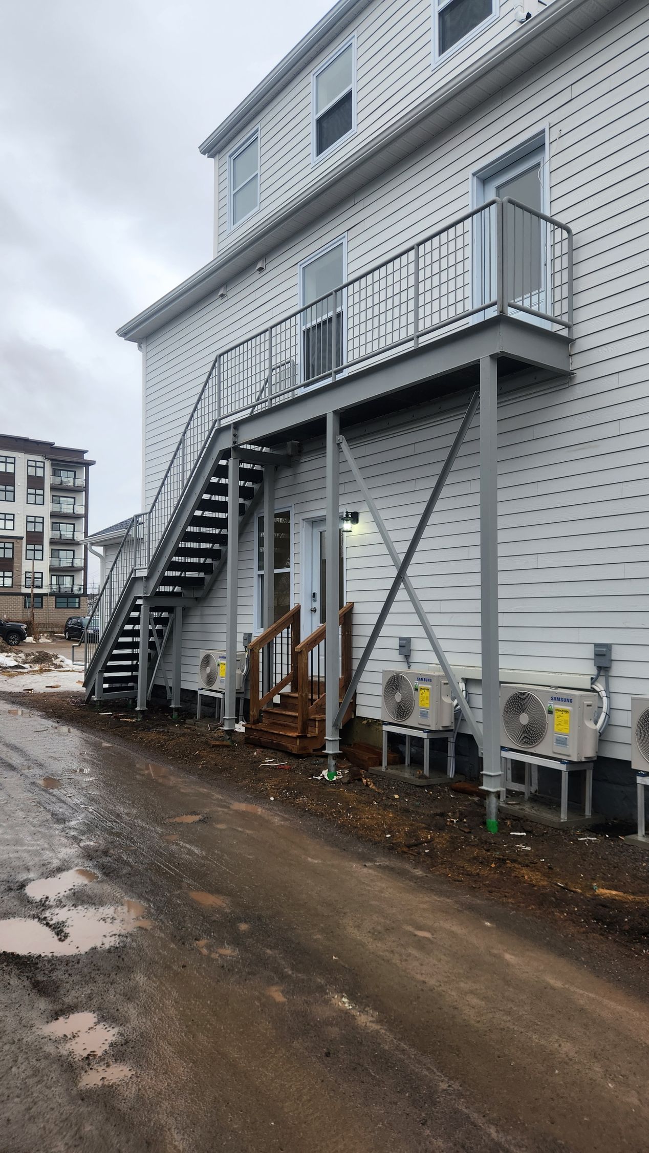 A white building with stairs on the side of it.