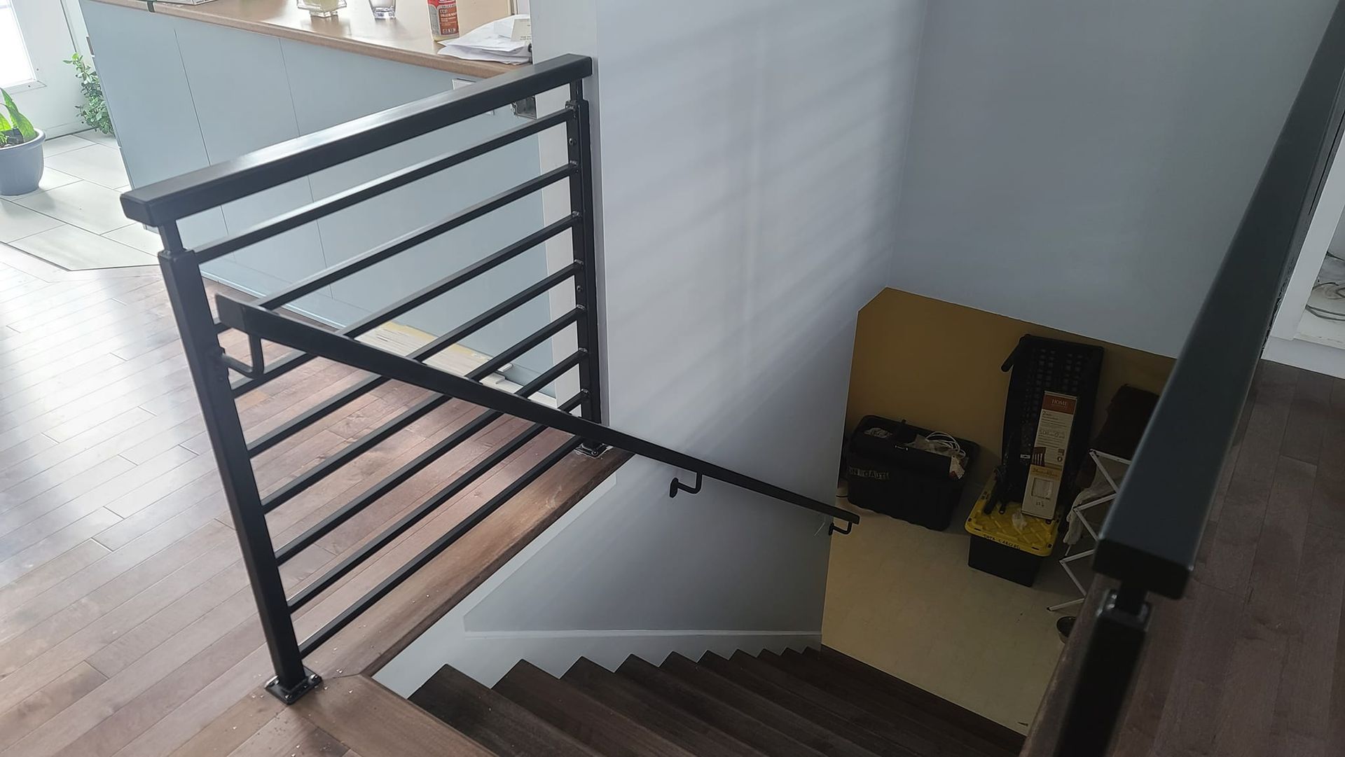 A staircase with a metal railing and wooden steps in a house.