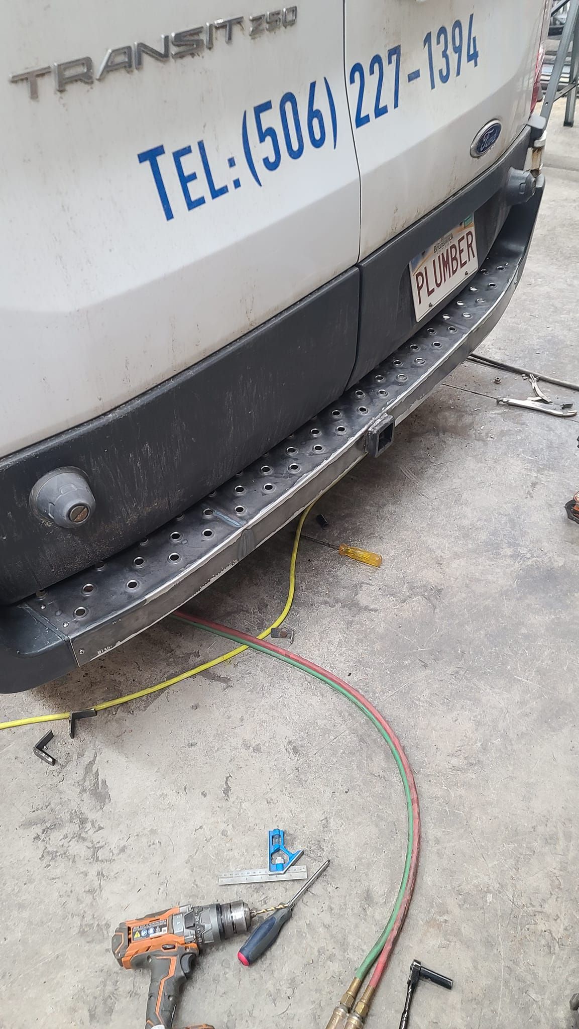 A white van is being worked on in a garage.