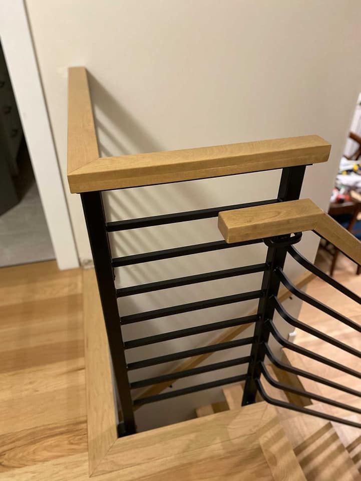 A close up of a wooden railing on a staircase.
