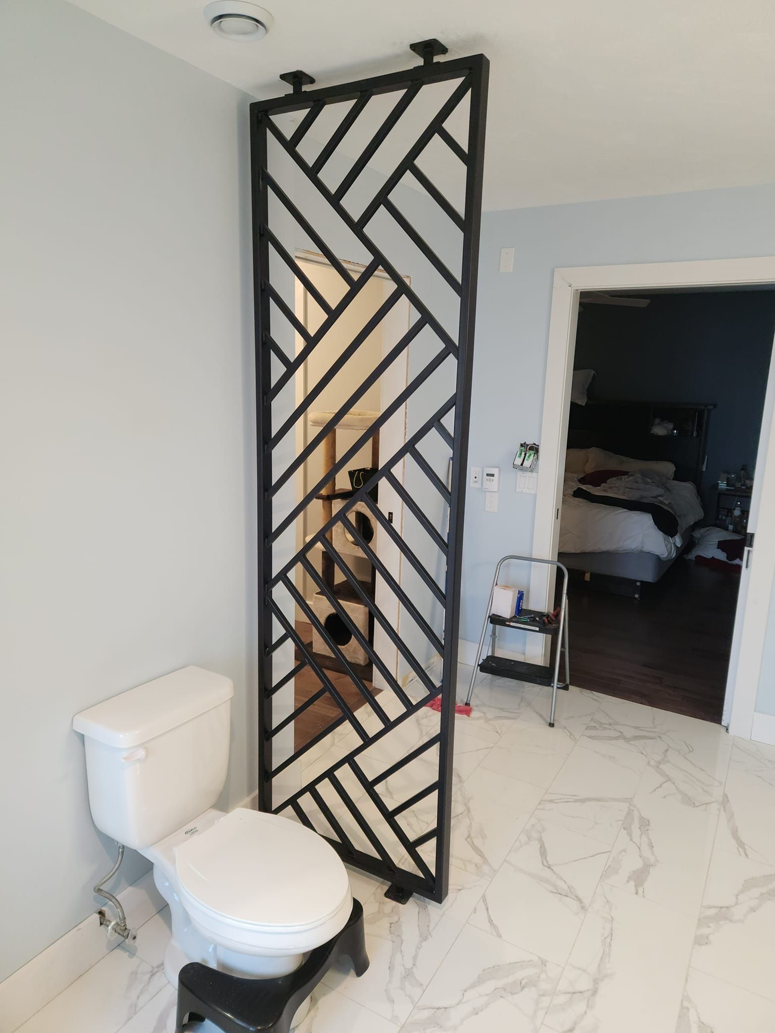 A bathroom with a toilet and a mirror on the wall.