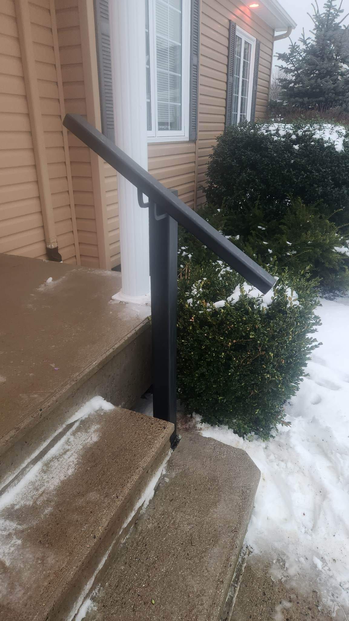 There is a railing on the steps of a house.
