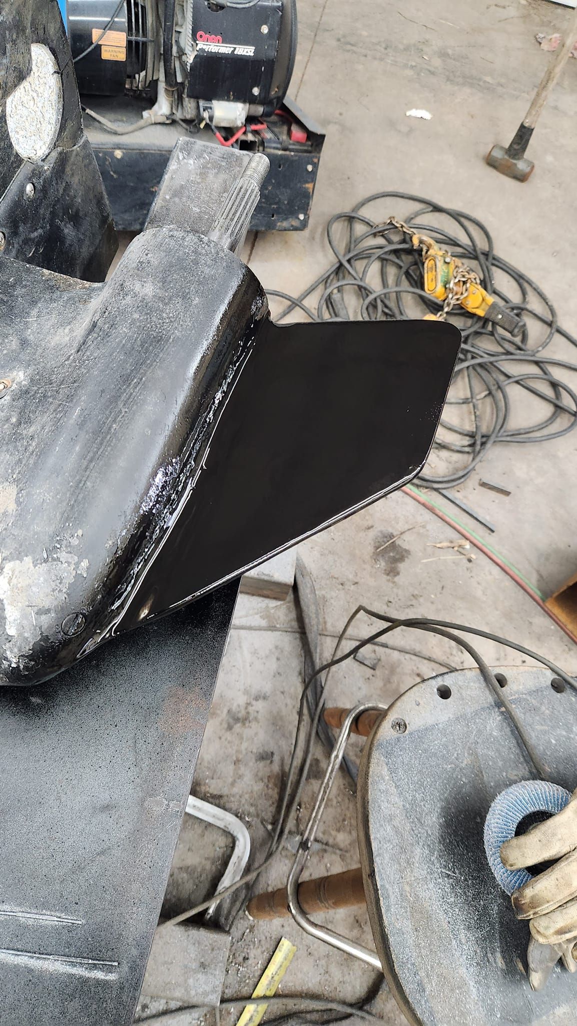 A piece of metal is laying on the ground in a garage.