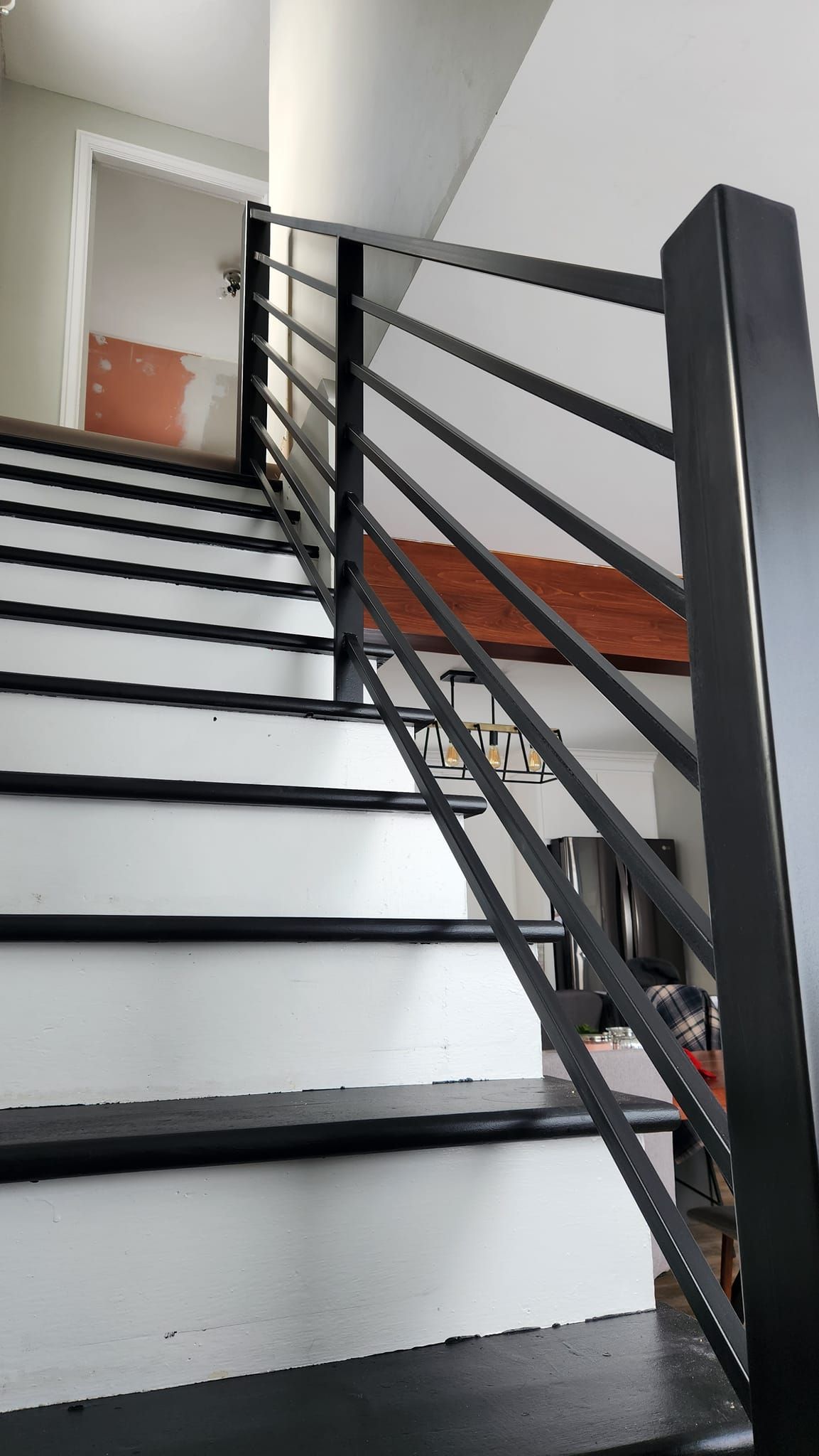 A staircase with black steps and a black railing in a house.