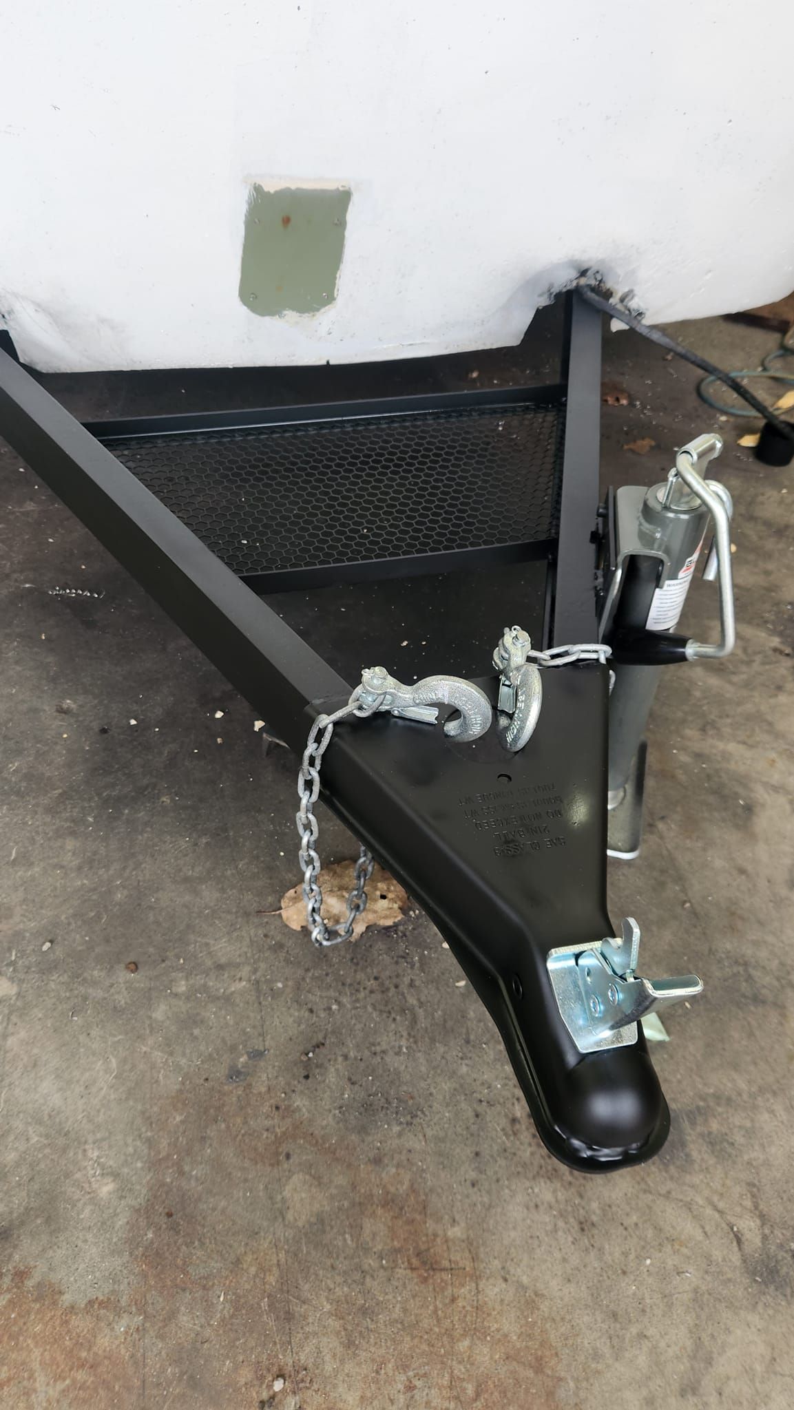 A trailer with a chain attached to it is sitting on the ground.