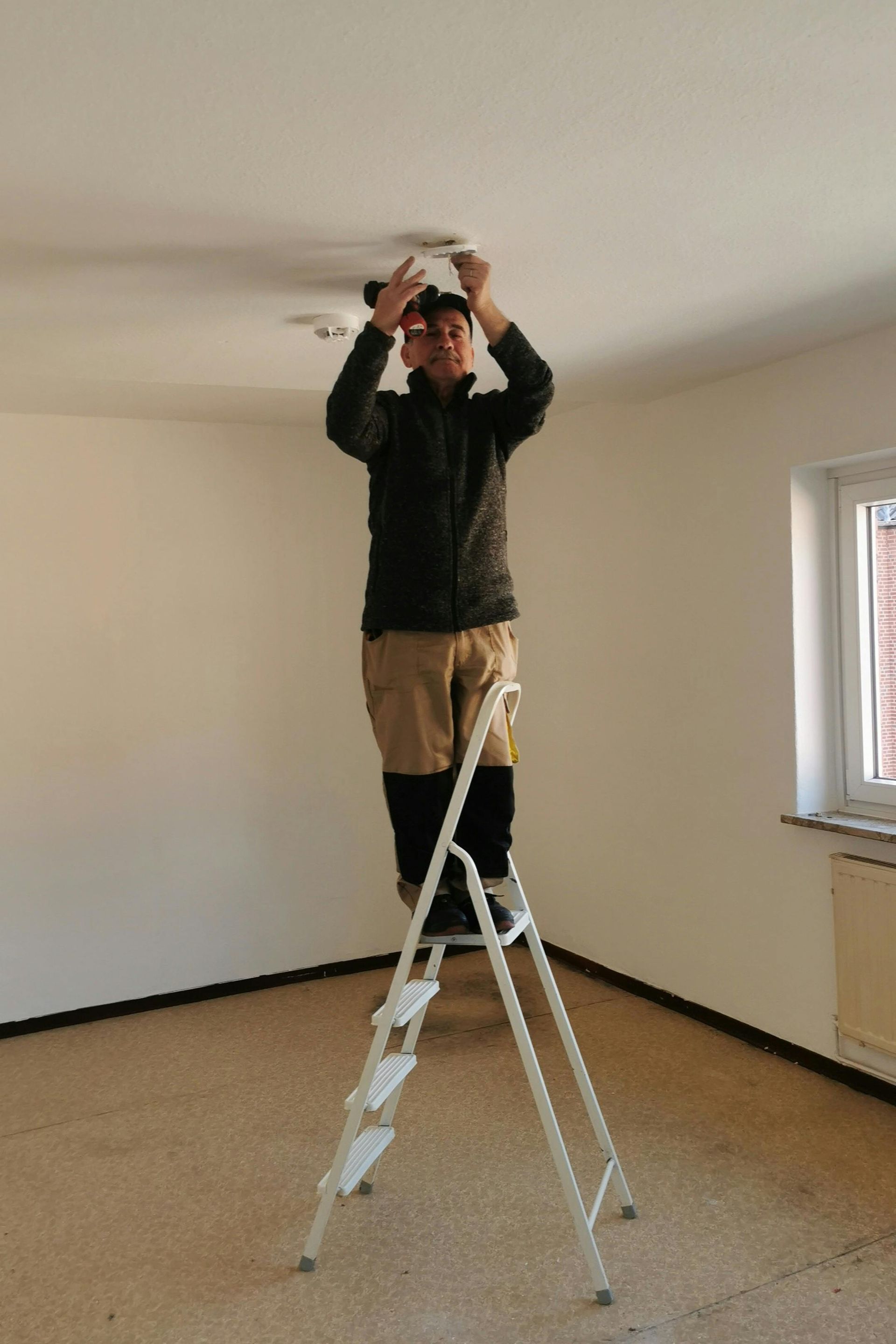Electrician installing ceiling lighting in a home in Rye, East Sussex