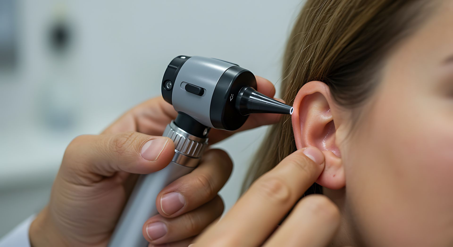 Ear being examined with an otoscope by a clinician in a medical setting