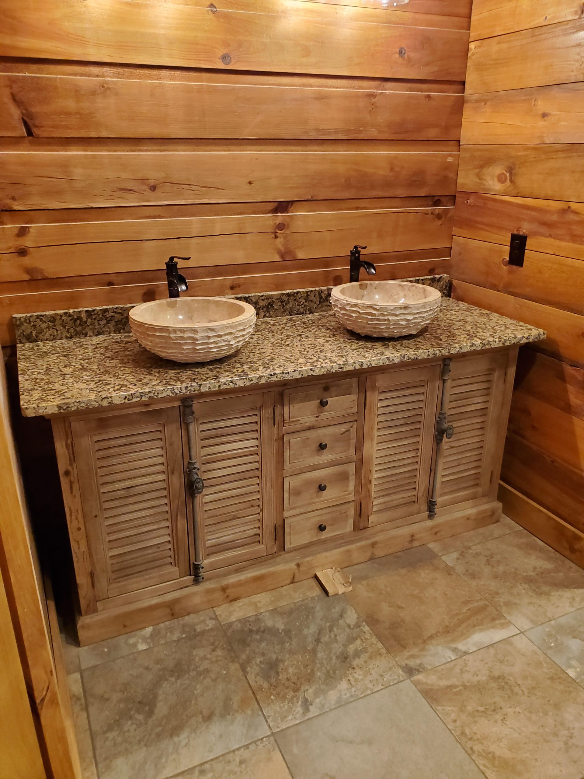 A bathroom with two sinks and a wooden cabinet.