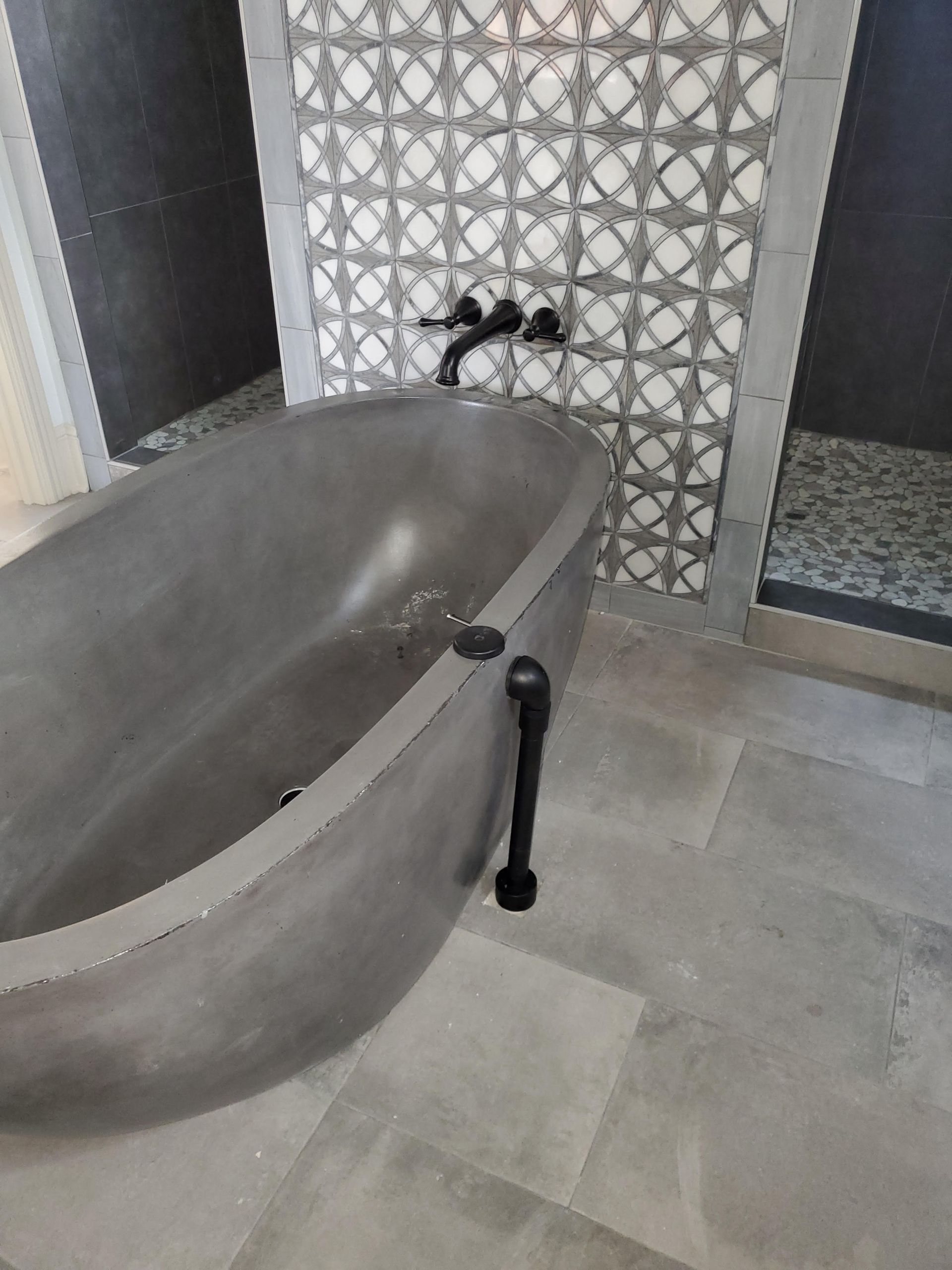 A bathtub is sitting in a bathroom next to a shower.