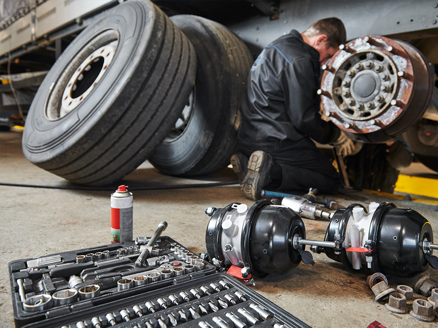 A man is working on a truck in a garage