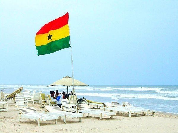 Flag of Ghana at a beach with sun loungers