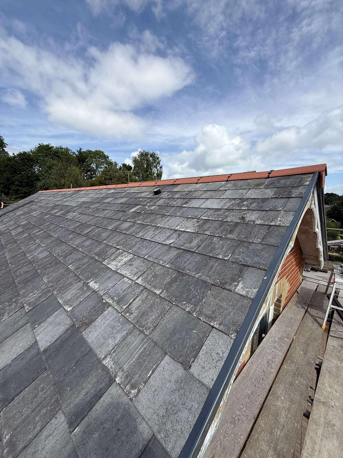 A roof with slate tiles is being built on a house.