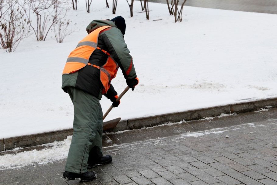 Person using a snow blower in winter.