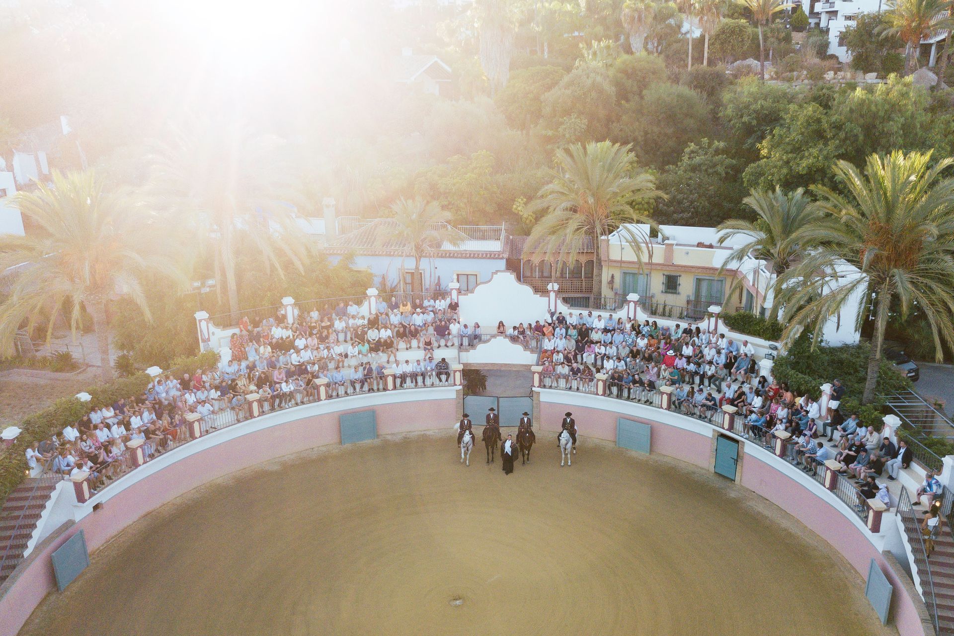 Et luftfoto av en tyrefekterarena fylt med mennesker og hester.