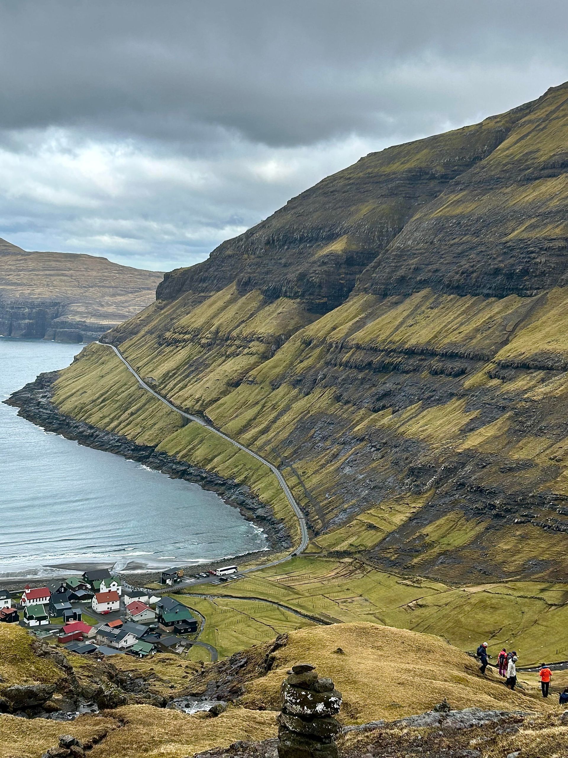En gruppe mennesker går ned en bakke ved siden av en vannmasse.