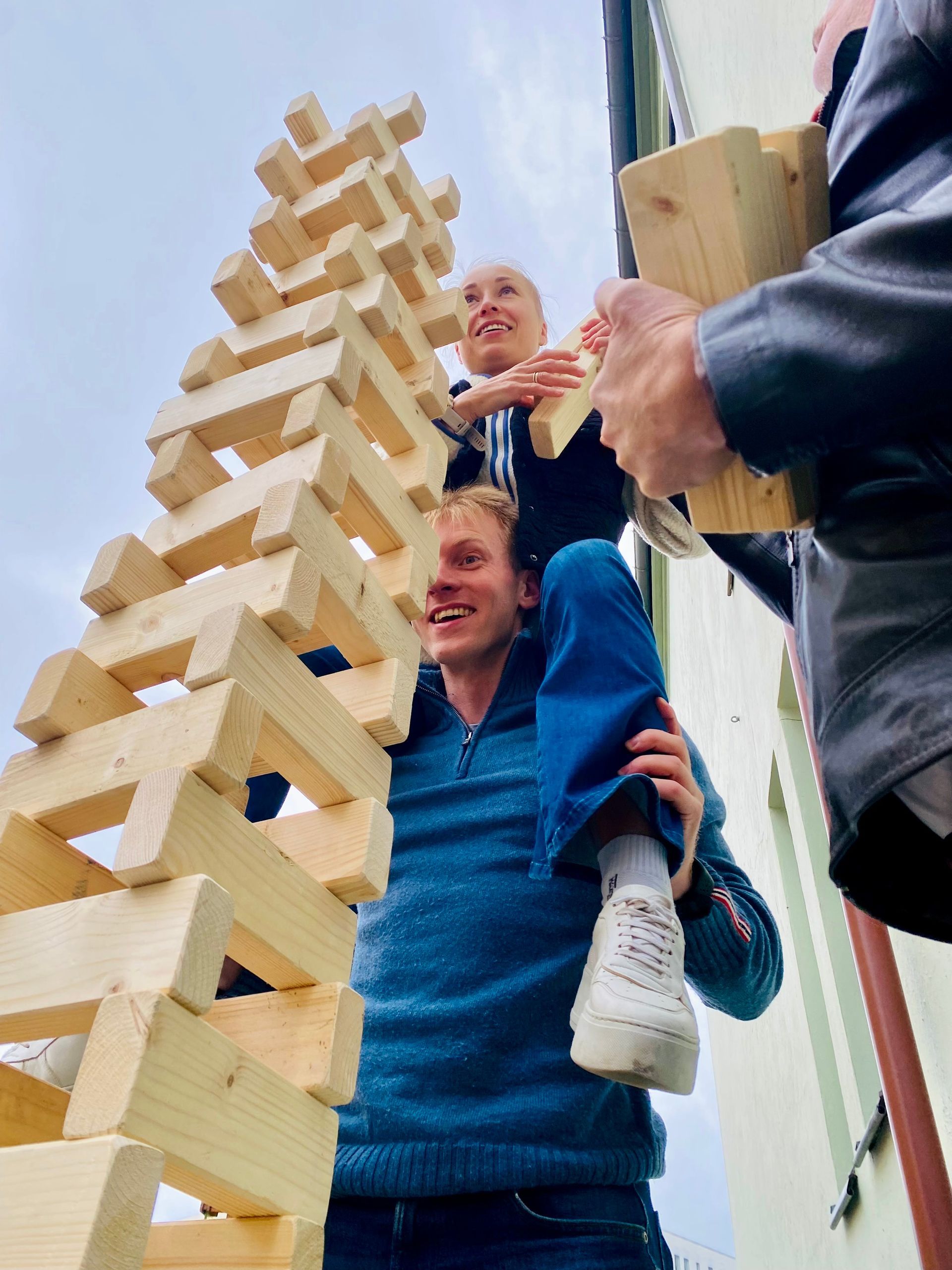 En mann bærer en kvinne på skuldrene mens han spiller en omgang jenga.