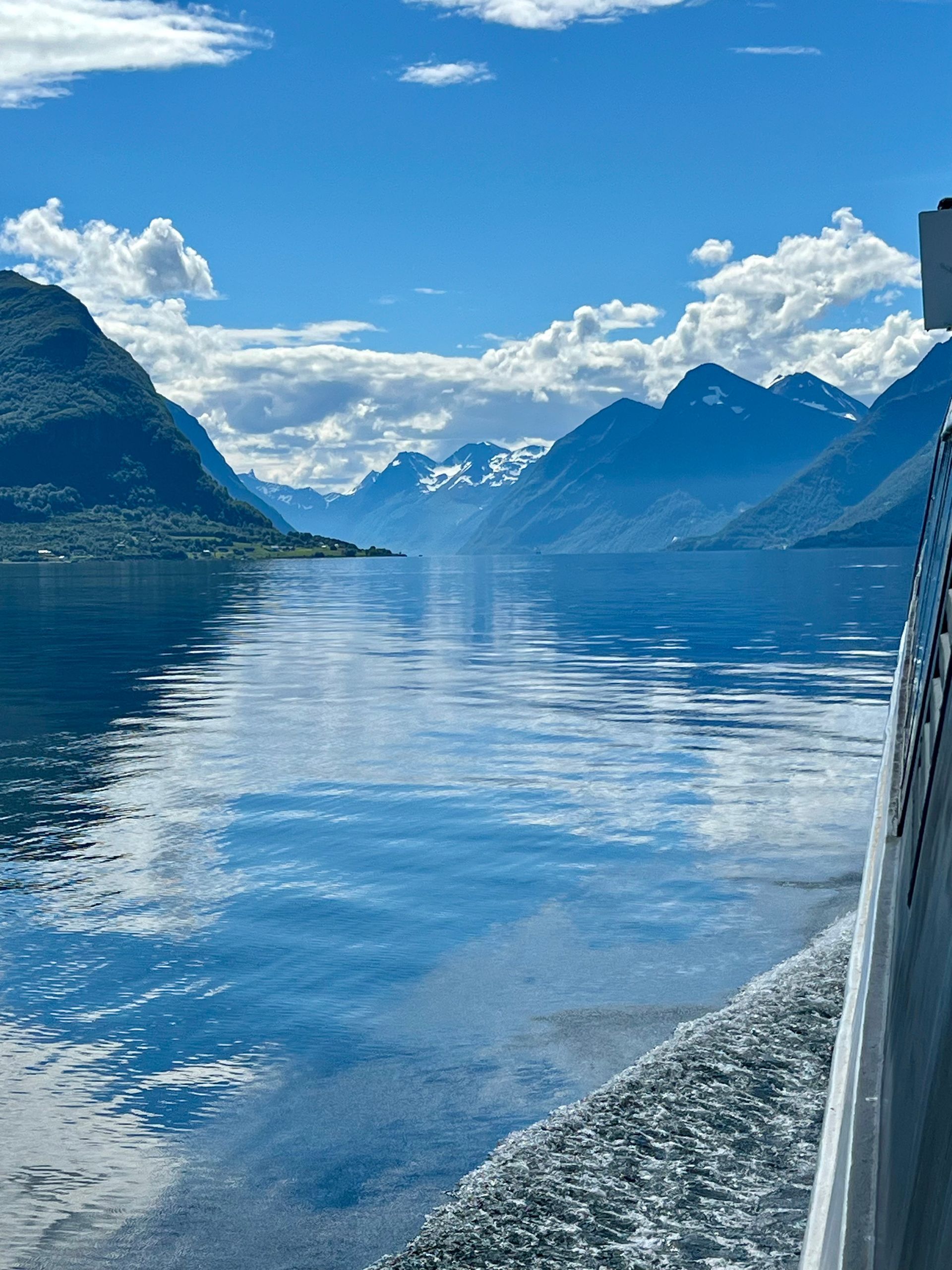En stor vannmasse med fjell i bakgrunnen