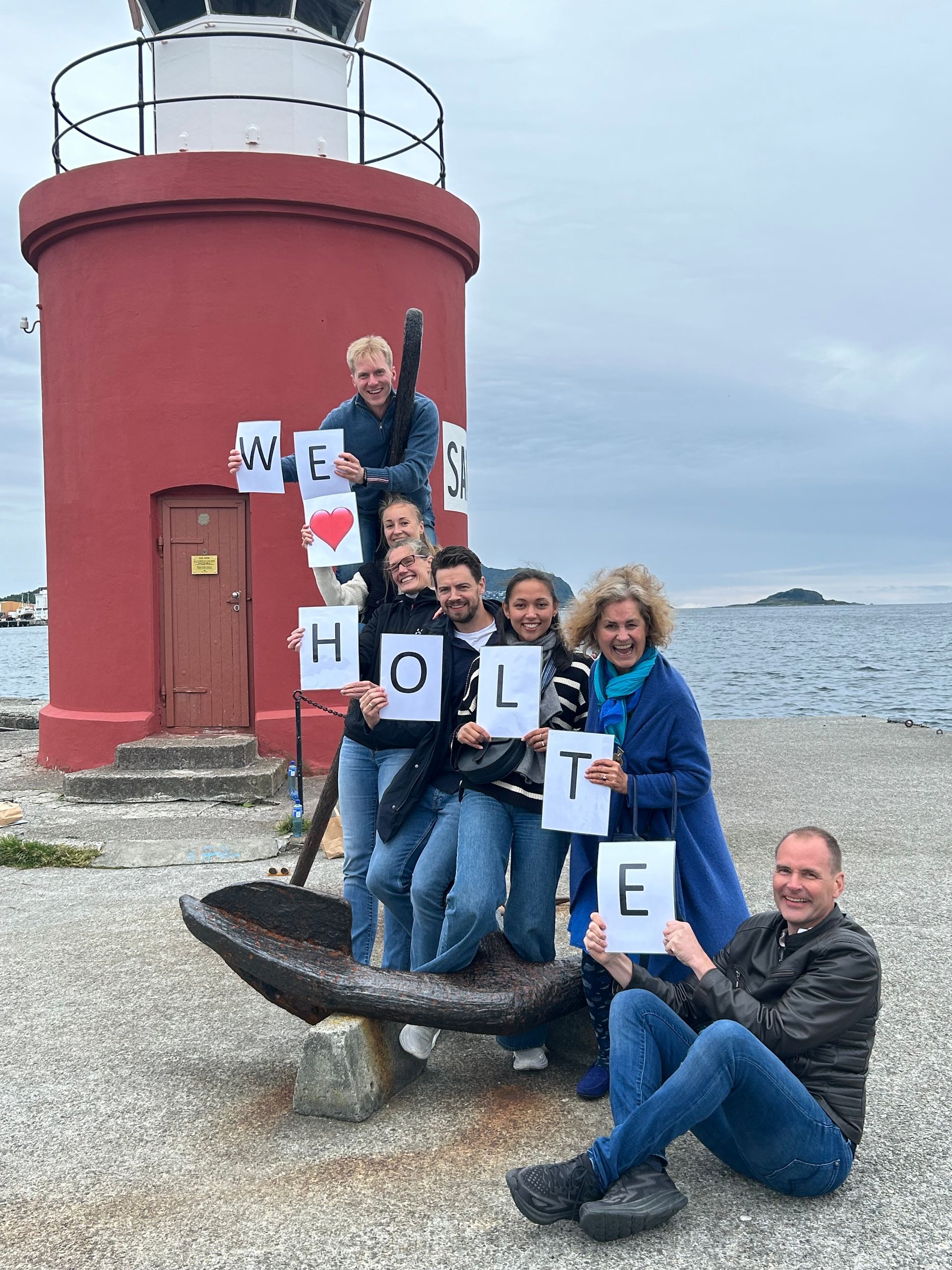 En gruppe mennesker som holder skilt som sier at vi elsker holte