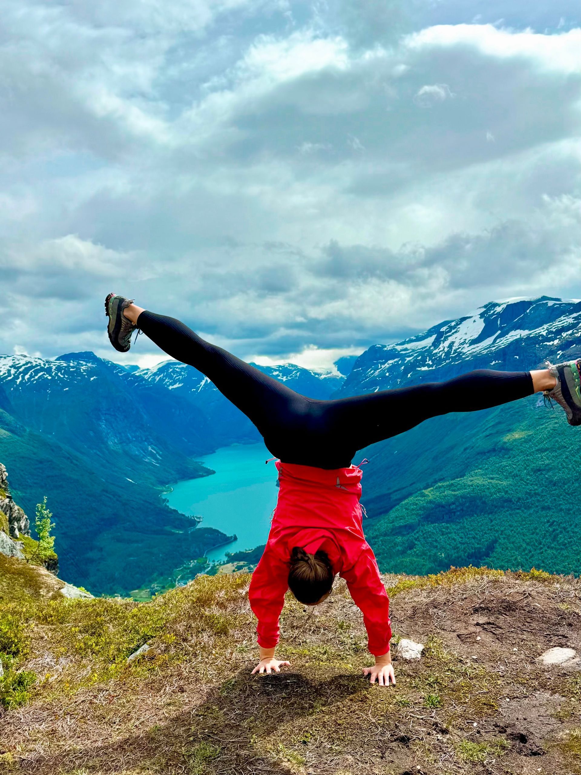 En person står i hånden på toppen av et fjell.
