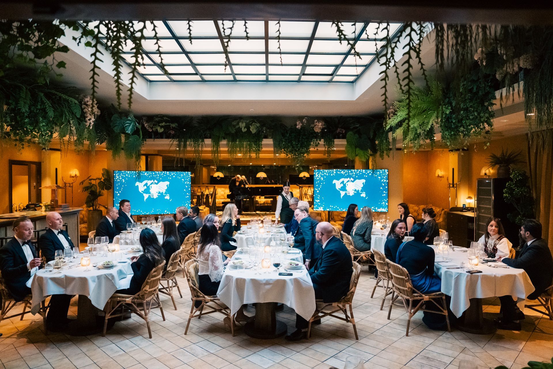 En gruppe mennesker sitter ved bordene på en restaurant.