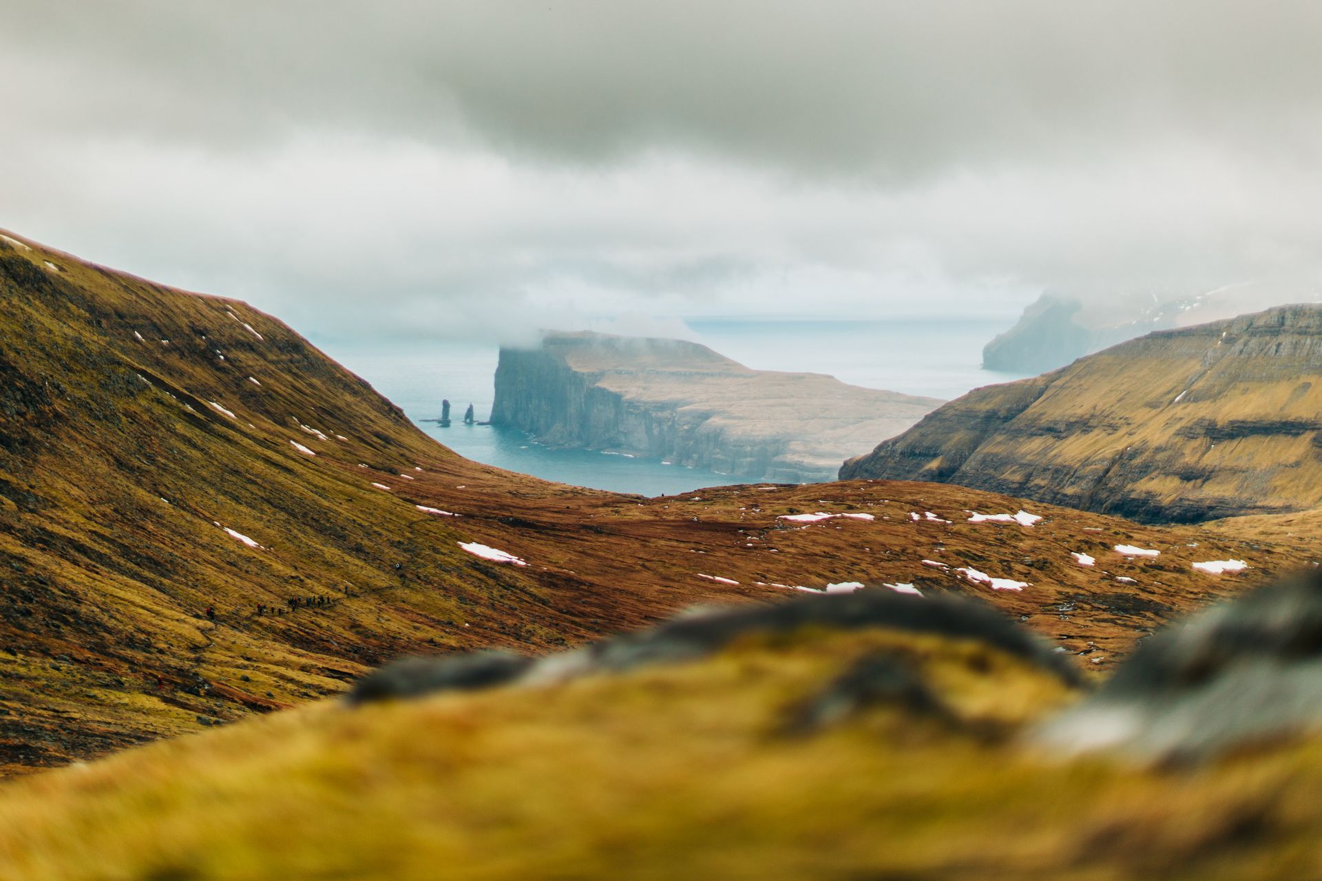 Utsikt over en dal med fjell og vann i bakgrunnen.