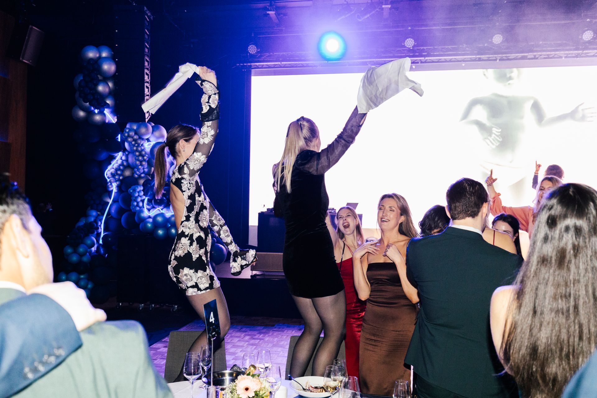 En gruppe mennesker danser på en scene på en fest.