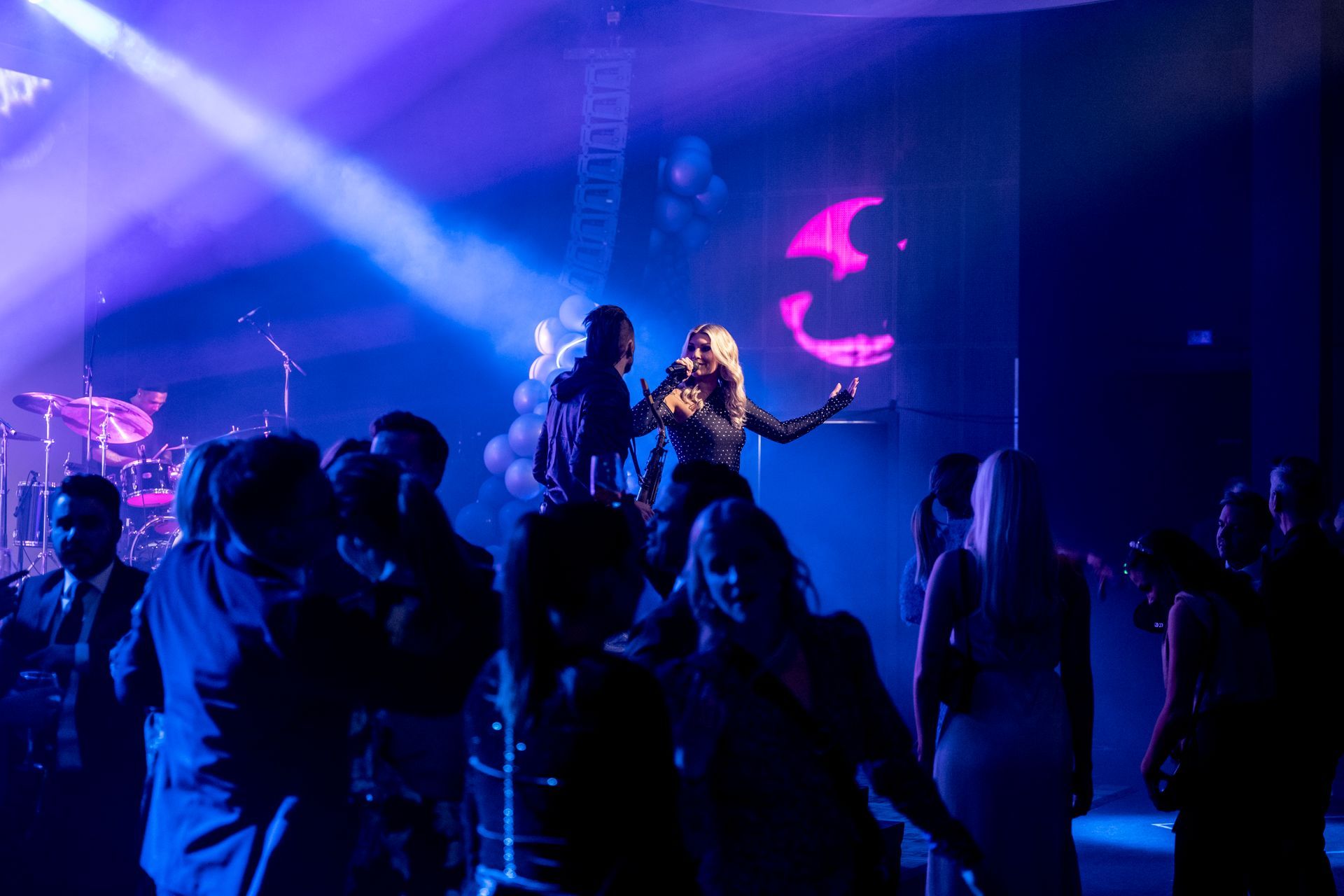 En gruppe mennesker danser i et mørkt rom på en konsert.