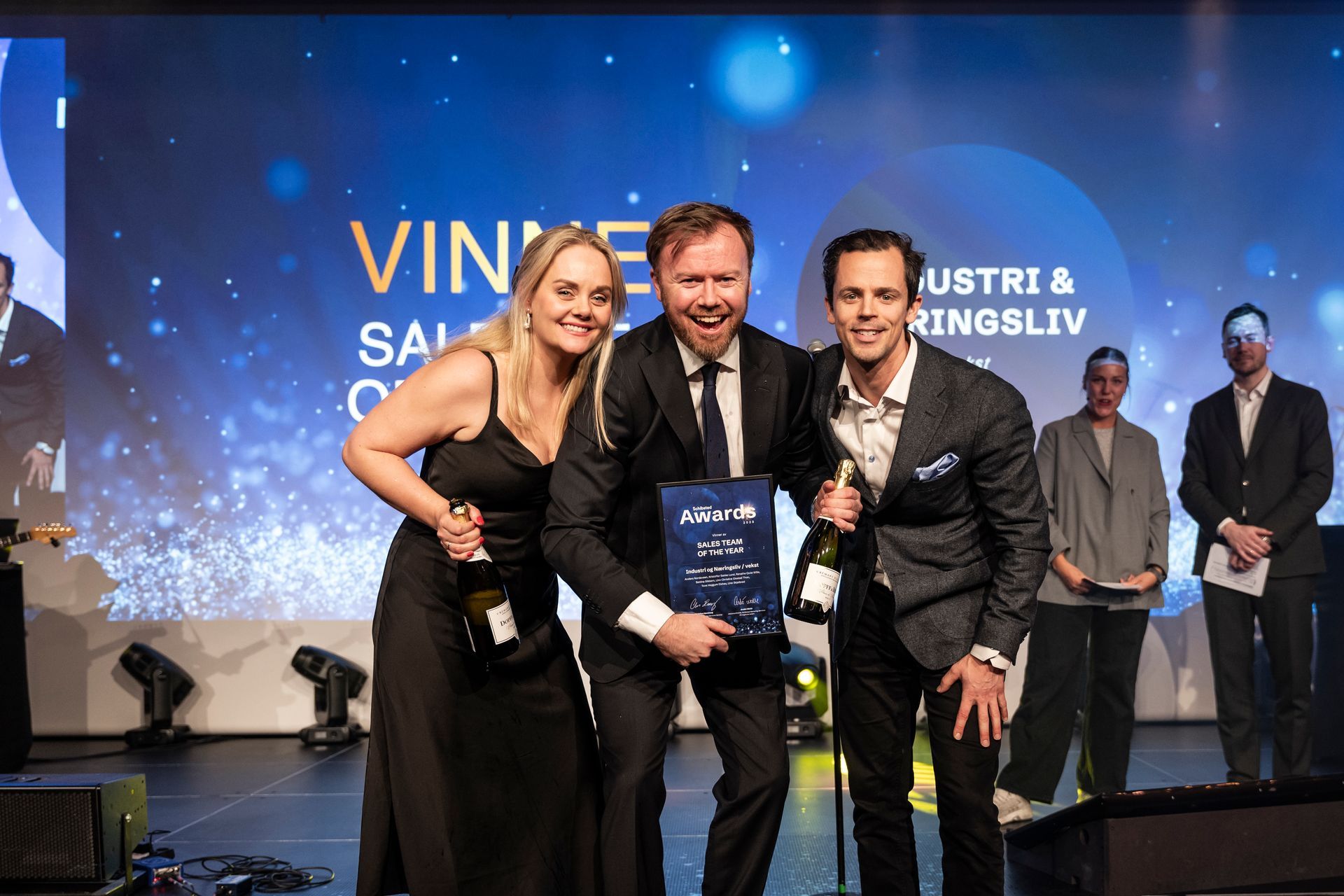 En gruppe mennesker poserer på en scene.