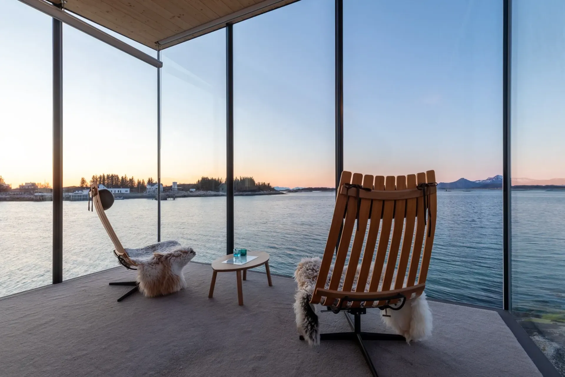 En stol og et bord i et rom med utsikt over en vannmasse