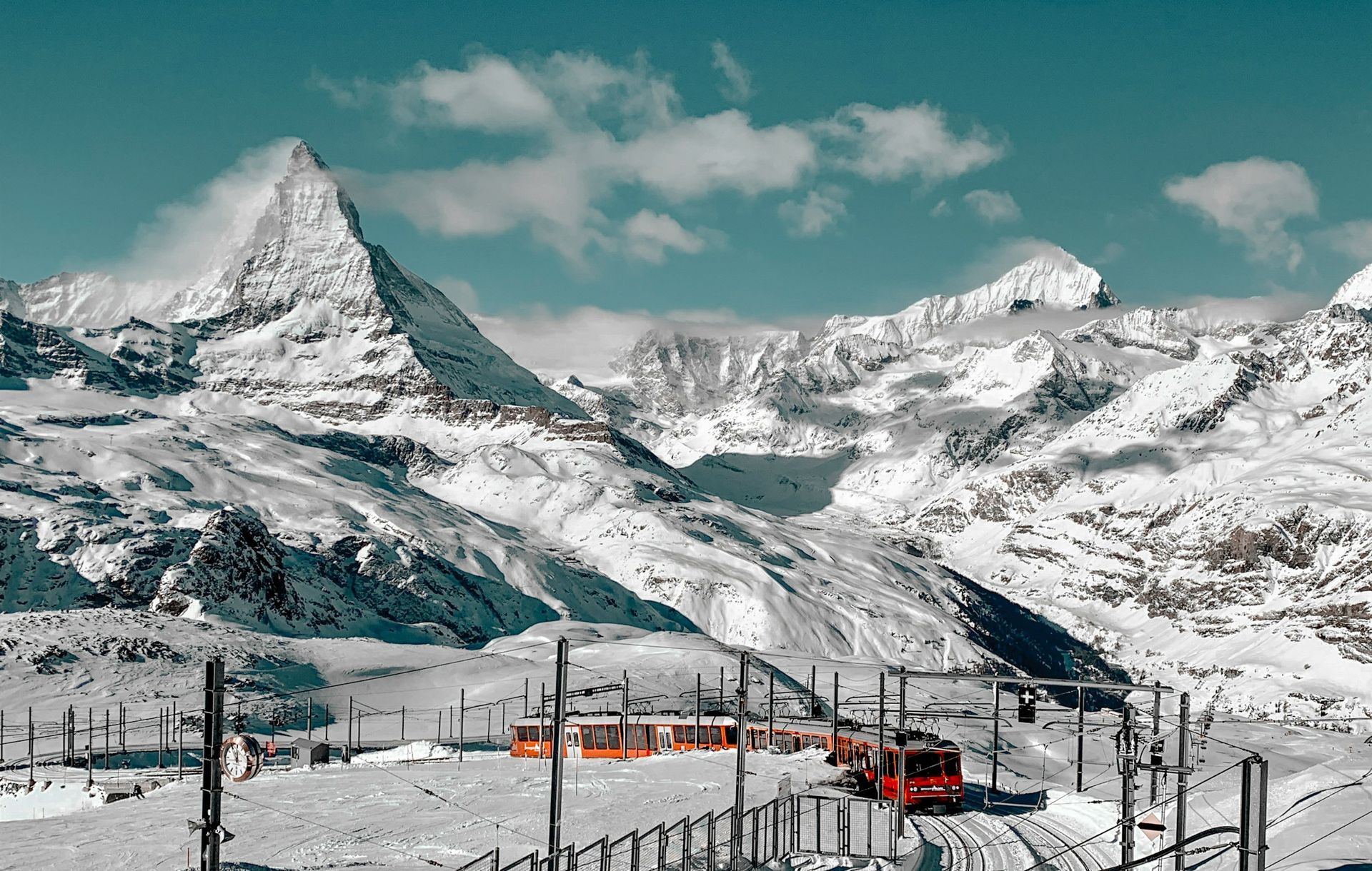 Et tog går gjennom en snødekt fjellkjede.